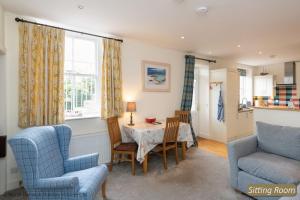 - un salon avec une table, des chaises et un canapé dans l'établissement Hopetoun Cottage, à Gullane