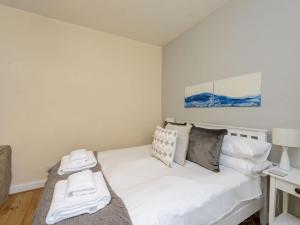a white bed in a room with a desk at Kittiwake in North Berwick