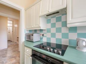 a kitchen with green and white tiles on the wall at Kittiwake in North Berwick
