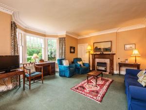 een woonkamer met blauwe meubels en een open haard bij Glenconner House in North Berwick
