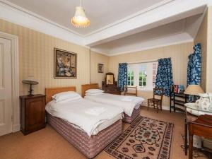 een slaapkamer met 2 bedden, een bureau en een piano bij Glenconner House in North Berwick