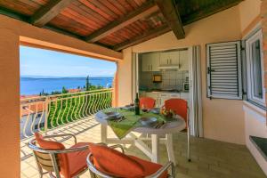 a table and chairs on a balcony with a view of the ocean at Apartments Matilda in Dramalj