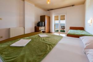 a hotel room with two beds and a balcony at Apartments Matilda in Dramalj