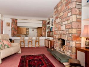 a living room with a large stone fireplace at Greylag Cottage in Gullane