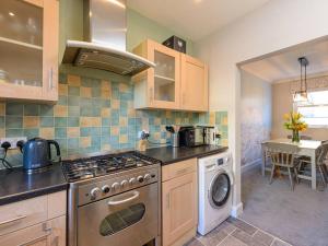 una cucina con fornello forno superiore accanto a un tavolo di Craigleith Lodge a North Berwick
