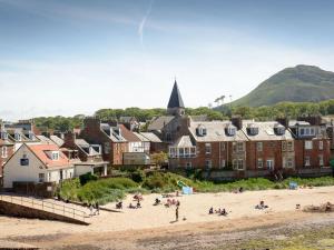 un gruppo di persone su una spiaggia vicino a una città di Craigleith Lodge a North Berwick