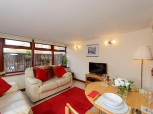 uma sala de estar com um sofá e uma mesa em Harmony Undercroft em North Berwick