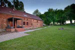 a brick building with a grass yard in front of it at Rokitnica 37 in Niesulice