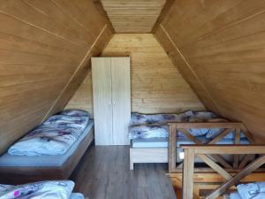 a room with two beds in a wooden cabin at Domki Dwa in Limanowa