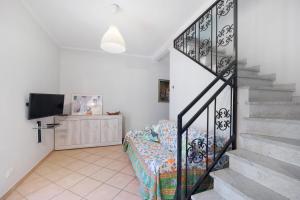 a room with a bed and stairs with a tv at The Family Free Parking in Alassio in Alassio