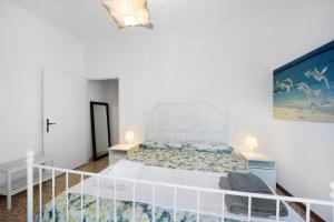 a white bedroom with a large bed with a white headboard at The Family Free Parking in Alassio in Alassio