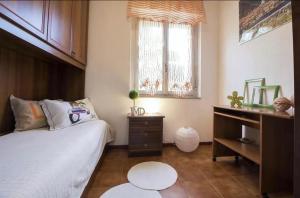 1 dormitorio con 1 cama, escritorio y ventanas en La casa delle janas, en Platamona