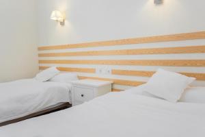 a bedroom with two beds and a wooden wall at Casa Lili in Moraira