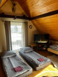 a bedroom with two twin beds and a television at Samsolandia Willa Falsztyn in Falsztyn