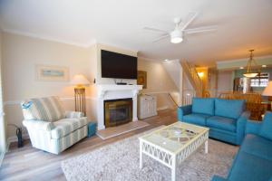 a living room with blue furniture and a fireplace at Harbour Island 21C townhouse in Ocean City