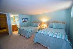 a bedroom with two beds with blue walls at Harbour Island 21C townhouse in Ocean City