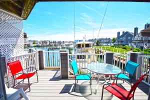 a balcony with chairs and a table and a view of the water at Harbour Island 21C townhouse in Ocean City
