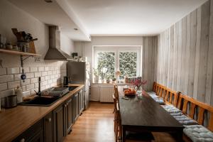 a kitchen with a table and a refrigerator at Dom Gościnny Tatra Nova in Długopole-Zdrój