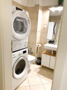 ein Badezimmer mit einer Waschmaschine und einem WC in der Unterkunft H & A Suite Gozsdu - THE 1001 NIGHTS SUITE in Budapest