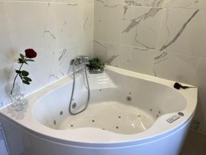 a white bath tub with a vase of flowers in it at Un moment de détente Maison avec balnéothérapie . in Prades