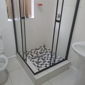 a shower with a checkered floor in a bathroom at Moonlight Guesthouse in Pretoria