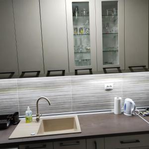 a kitchen counter with a sink and some shelves at Downtown penthouse Šabac in Šabac