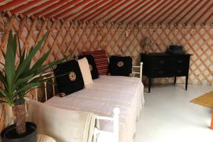 - une chambre avec un lit blanc dans une yourte dans l'établissement Gilfach Gower Farm Luxury Yurt with Hot Tub, à Ammanford