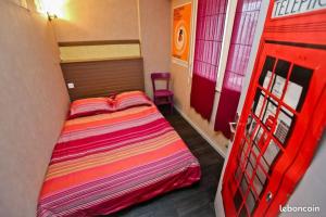- une petite chambre avec un lit et une porte rouge dans l'établissement Appartement centre-ville Rennes, à Rennes