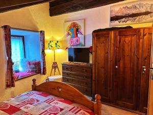 1 dormitorio con 1 cama y vestidor con TV en Meizon - La Montagna, Pila, Crevacol, Aosta e Valpelline, en Gignod