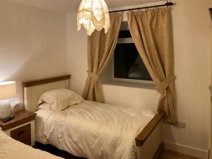 - une chambre avec 2 lits et une fenêtre dans l'établissement Cherry Tree Cottage, à Stranraer