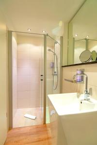 a bathroom with a shower and a sink and a mirror at Hotel am Fischerstrand in Bansin