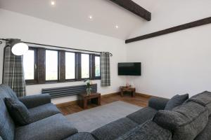 sala de estar con 2 sofás y TV de pantalla plana en NEW BARN CONVERSION WITH PRIVATE HOT TUB, en Halifax