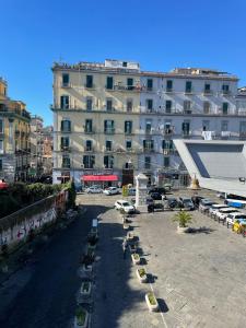 ein großes weißes Gebäude mit Autos auf einem Parkplatz in der Unterkunft House of the Sun in Neapel