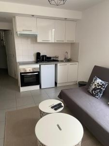 a living room with a couch and a table and a kitchen at Au cœur de St Jean Cap Ferrat in Saint-Jean-Cap-Ferrat