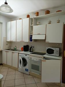 a kitchen with white cabinets and a washing machine at Tramonto sul Castello di Poppi in Poppi