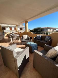 Un patio con sofás y sillas y una mesa. en Casa Boi Dessena 1, en Orosei