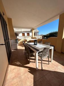 奧羅塞伊的住宿－Casa Boi Dessena 1，阳台上配有白色的桌椅