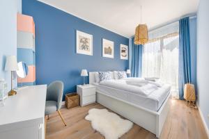 a blue bedroom with a bed and a desk at Gdynia Nowe Orłowo, Sun & Snow in Gdynia