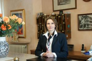 uma mulher sentada numa mesa numa sala em Hotel Verudella em Rimini