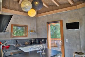 a kitchen with a counter and a tv on the wall at Chalet dans les Arbres in Saint-Jean-d'Aulps