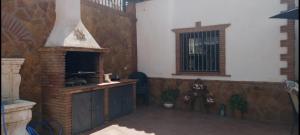 d'une terrasse avec une cheminée en briques et une fenêtre. dans l'établissement Casa Cueva Soledad, à Guadix