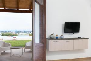 ein Wohnzimmer mit einem TV an der Wand in der Unterkunft emozioni di casa Barone in Scicli
