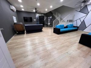 a living room with two blue couches and a staircase at Mekming Lodging - Homestay in Melaka +24 photos