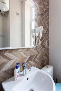 ein Badezimmer mit einem Waschbecken, einem Spiegel und einem WC in der Unterkunft Апартаменты на Гиршмана 4 in Kharkov