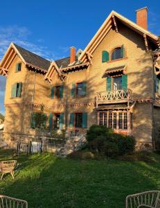 a large house with a porch on a lawn at O'Cottage double jardin in Annonay