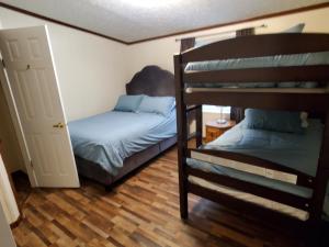 a bedroom with two bunk beds and a open door at Forest Hills ATV Resort 