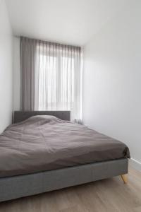 Ce lit se trouve dans un dortoir blanc doté d'une fenêtre. dans l'établissement K50169 Modern apartment near the center and free parking, à Eindhoven