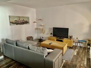 a living room with a couch and a flat screen tv at Au coeur du vignoble (Verzenay) in Verzenay