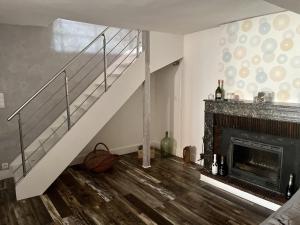 een woonkamer met een trap en een open haard bij Au coeur du vignoble (Verzenay) in Verzenay
