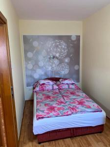ジュラにあるBíbor Apartmanのベッドルーム1室(壁に絵画が描かれたベッド1台付)